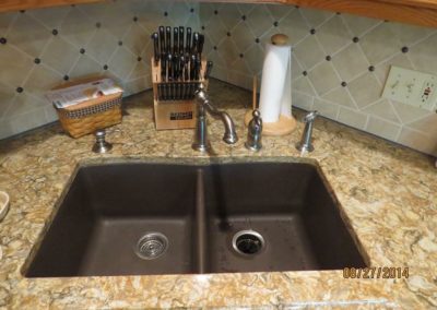 A brand new kitchen sink and granite counter instalaltion.