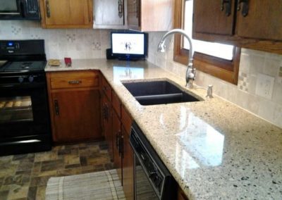 A newly installed kitchen sink and granite countertop.