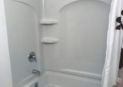 A white, plastic-sided shower installation.