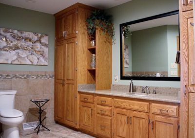 A large master bathroom with wooden cupboards.